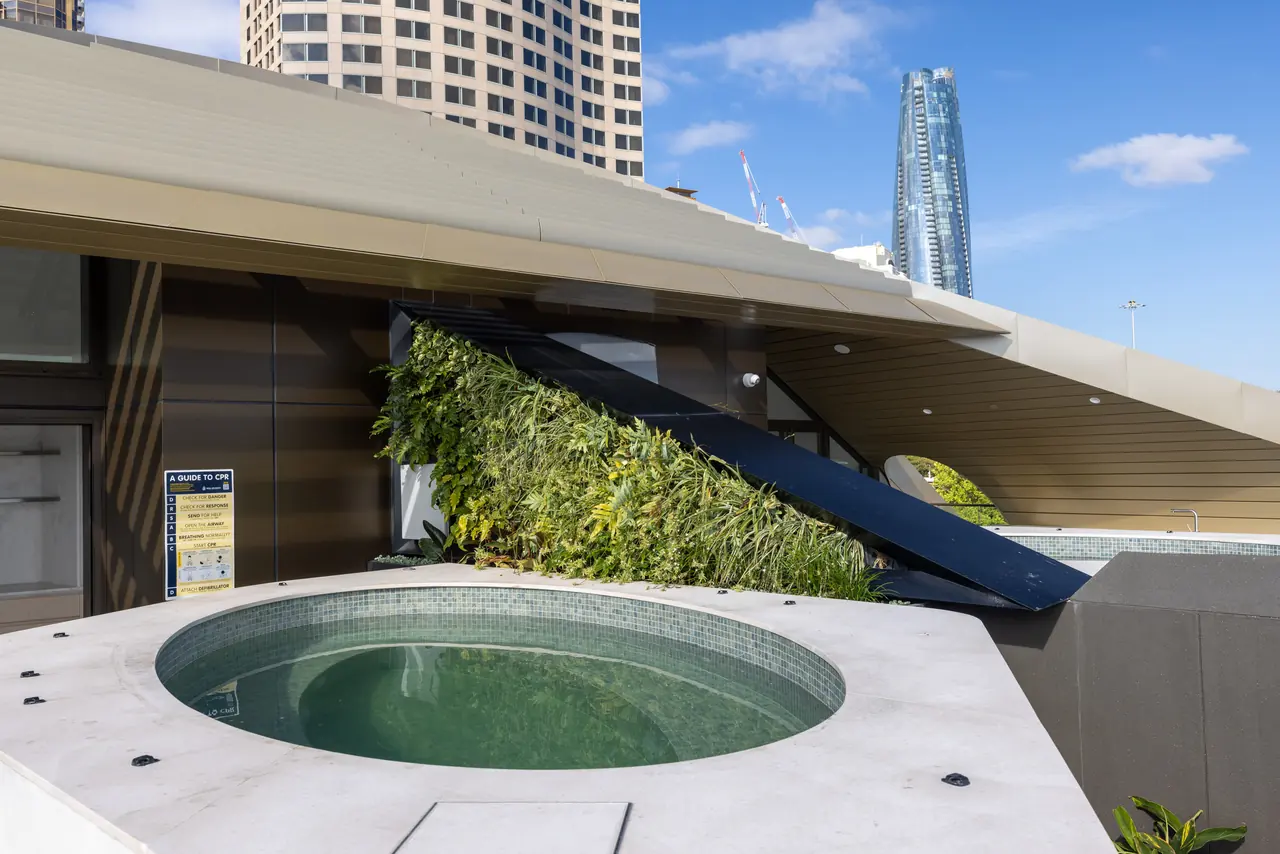 Circular sunken spa in sea-green mosaic under the roof canopy, Harrington Street