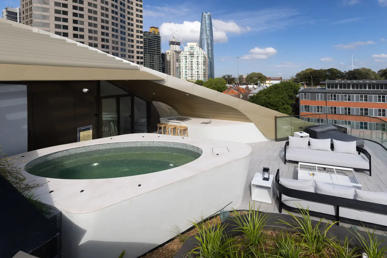 Oval spa set into the wide coping beside an outdoor lounge, Harrington Street