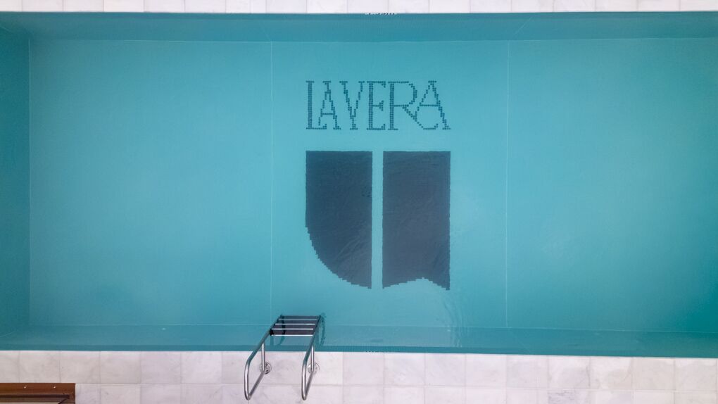 Aerial view of the La Vera name set into the pool floor in dark mosaic