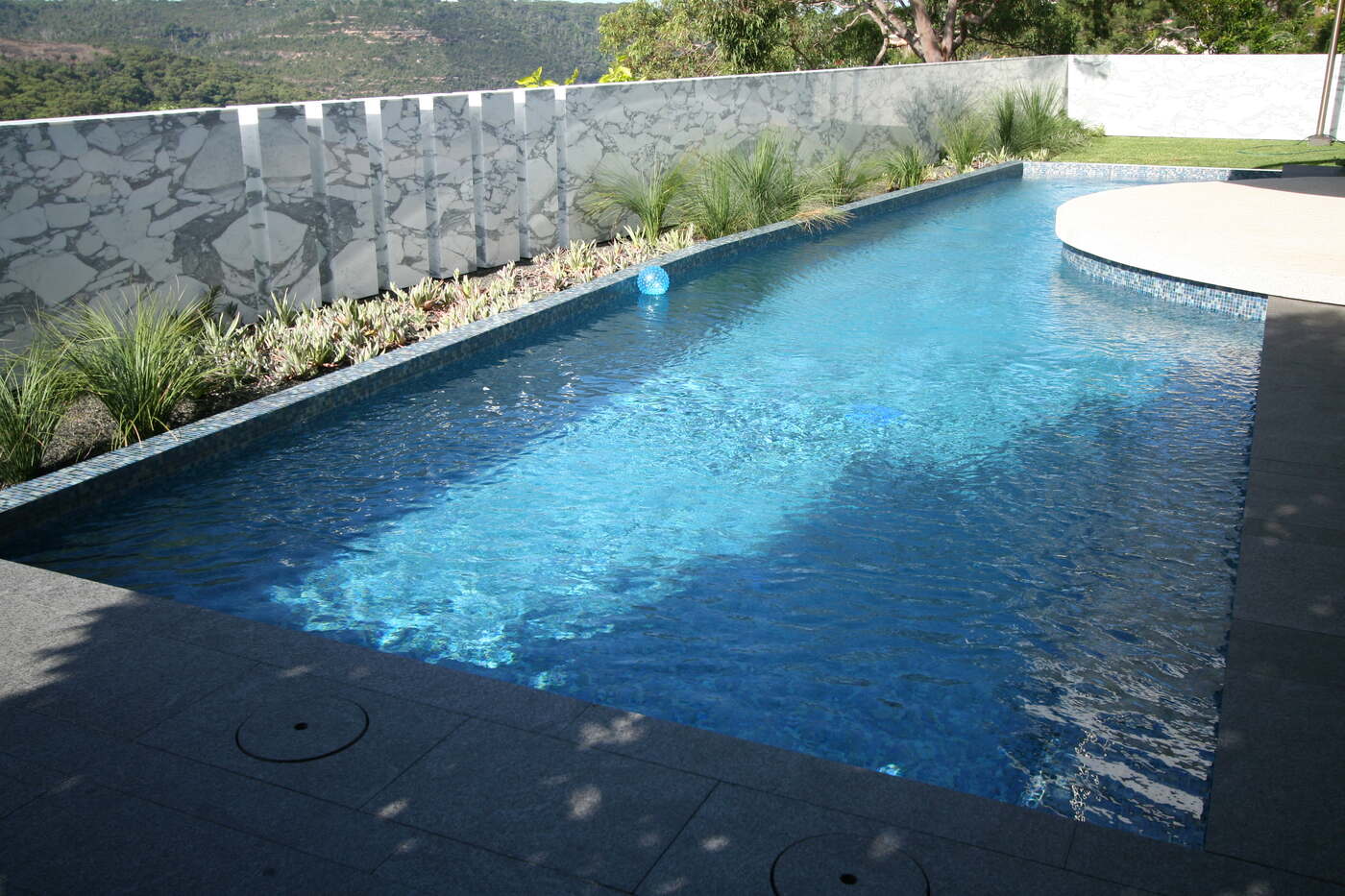 Scard Residence lap pool and stone wall in full sun, Castle Cove