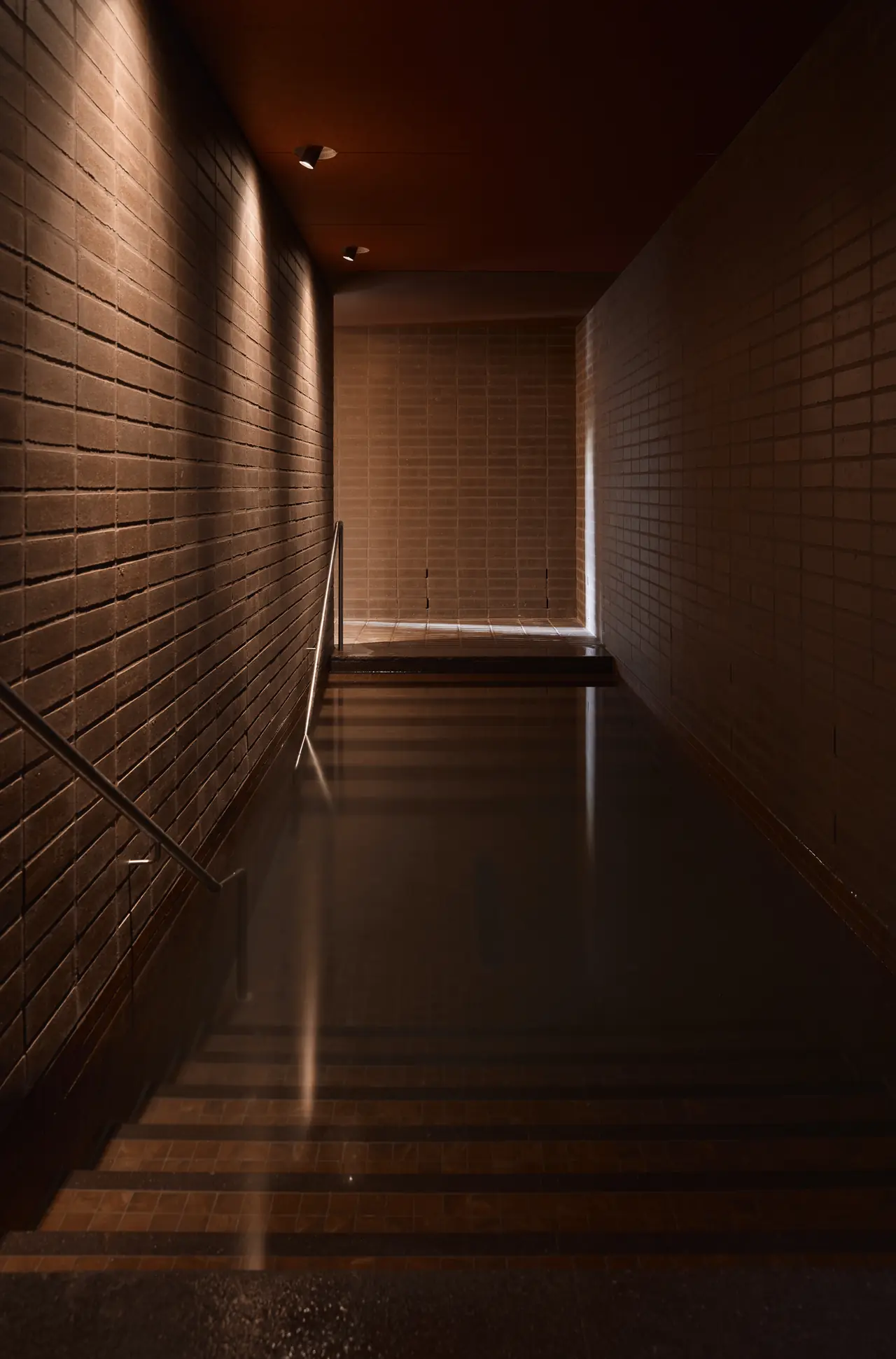 Walk-through cold plunge between brick walls, Sense of Self bathhouse