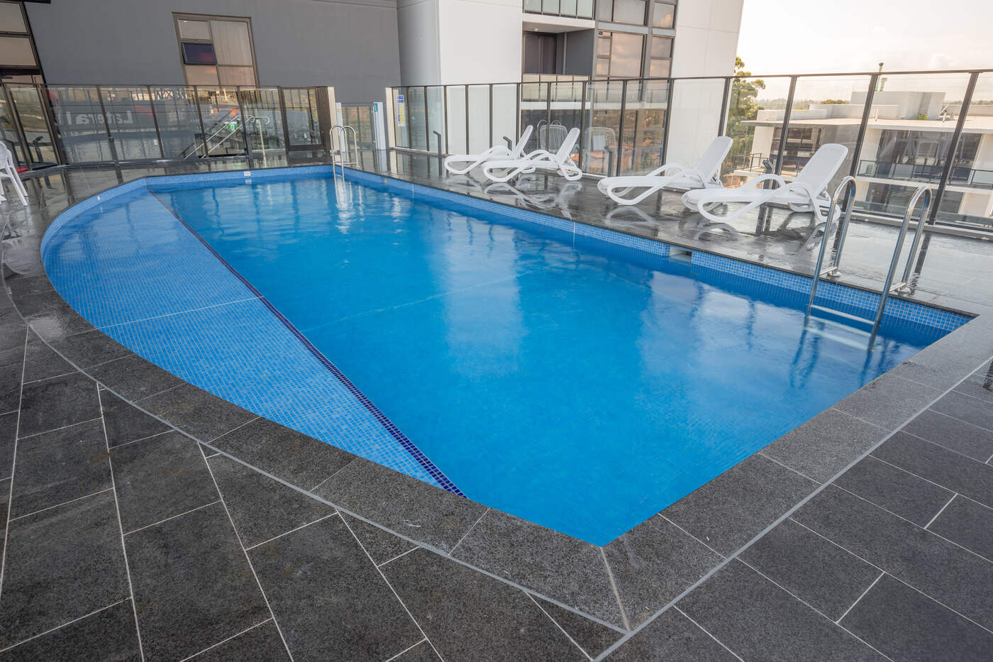 Blue mosaic pool with loungers, Skyhaus Liverpool