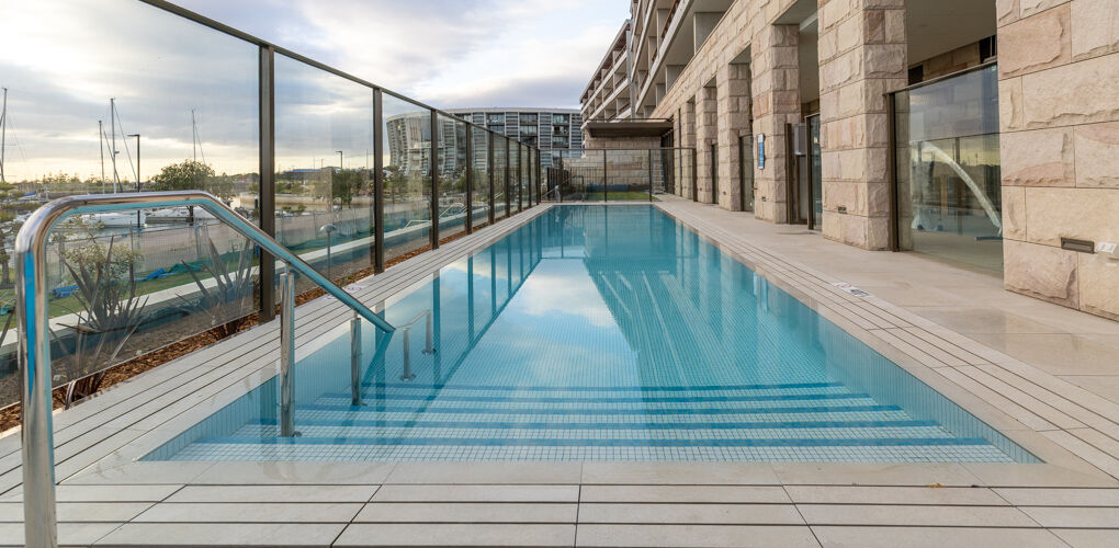 Stainless rails down the lap pool with marina beyond, Vela Apartments